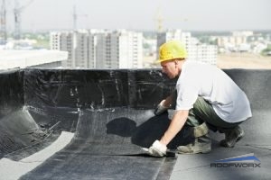 Roofer Installing Sheets of Roof Membrane